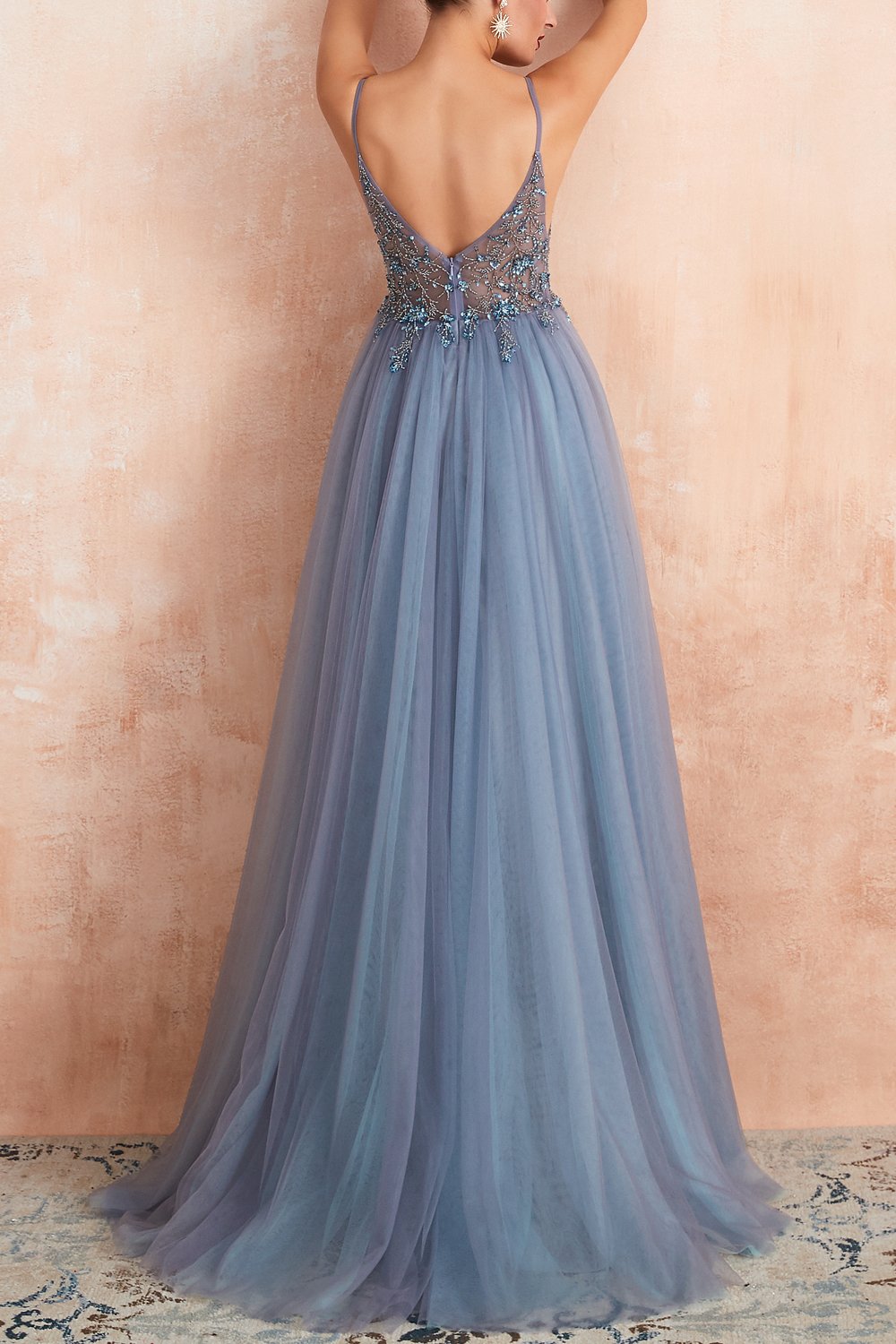 Frau in blauem Abendkleid mit Spitze und Tüll, elegantes Design, Rückansicht.
