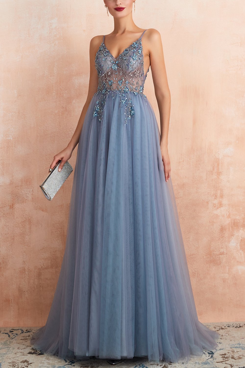 Frau in blauem Abendkleid mit Spitze, hält silberne Clutch, elegantes Ballkleid, Abendmode.