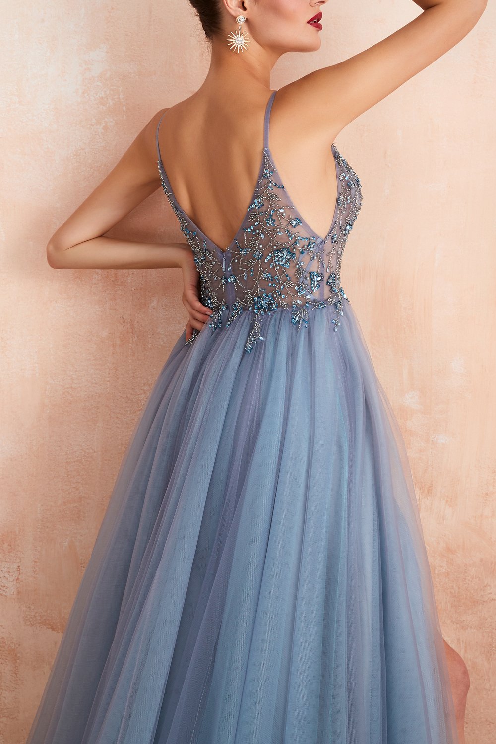 Frau in blauem Abendkleid mit Tüllrock und besticktem Oberteil, elegantes Design, Modefotografie.