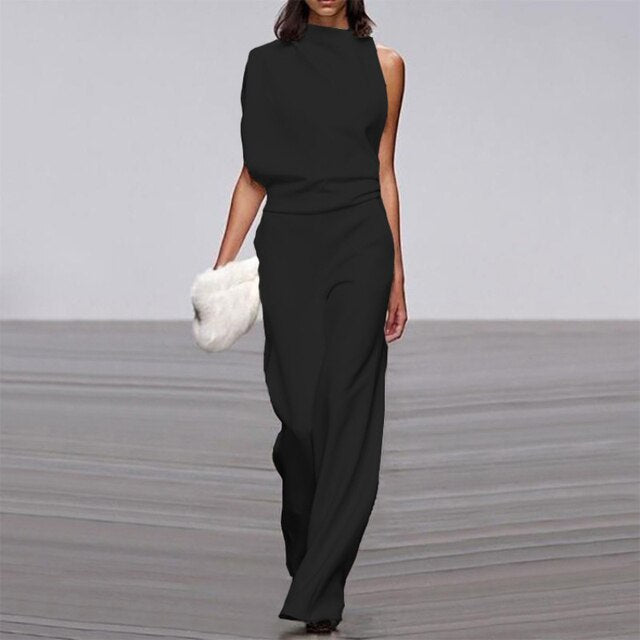 Frau in schwarzem, ärmellosem Jumpsuit mit weitem Bein, hält weiße Clutch, elegantes Design.